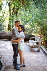 happy couple in love after the proposal in muir woods