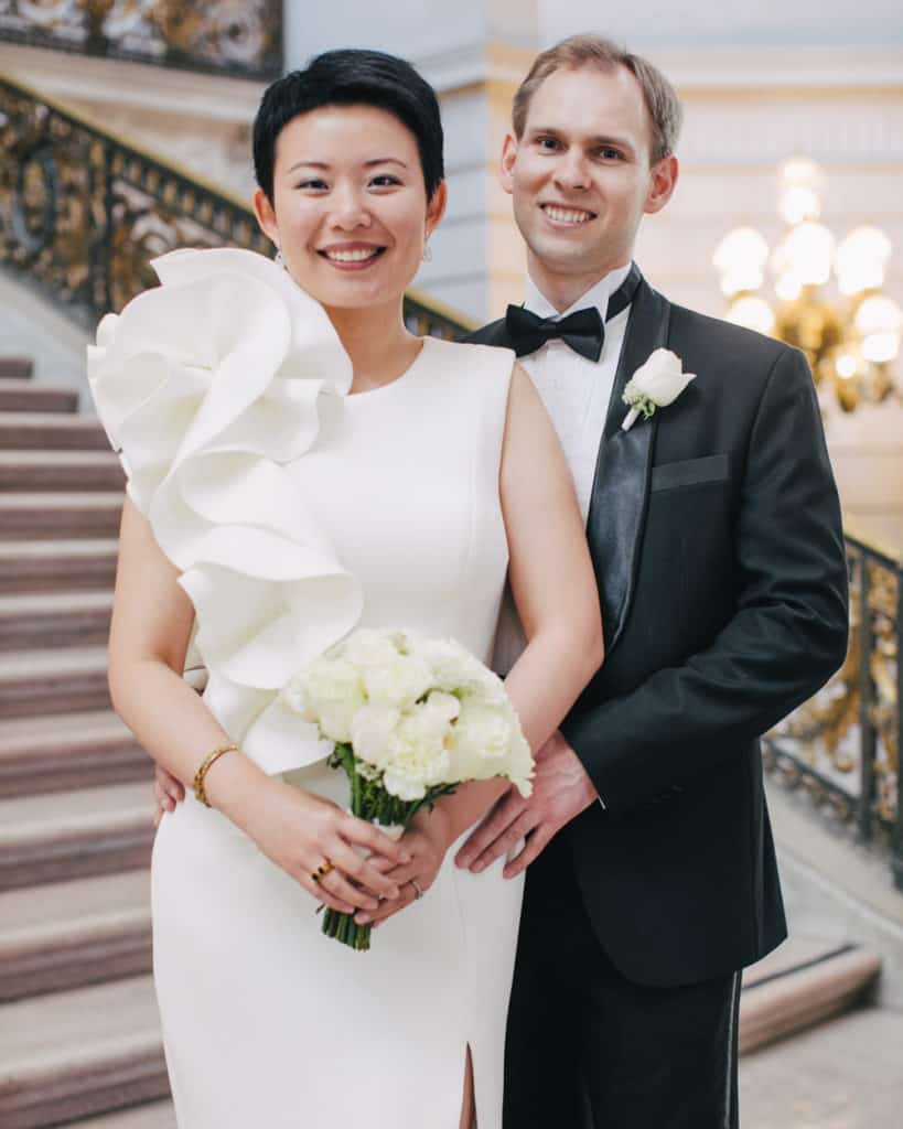 a bride in a unique retro gown holding a bouquet posing on the Grand Staircase
