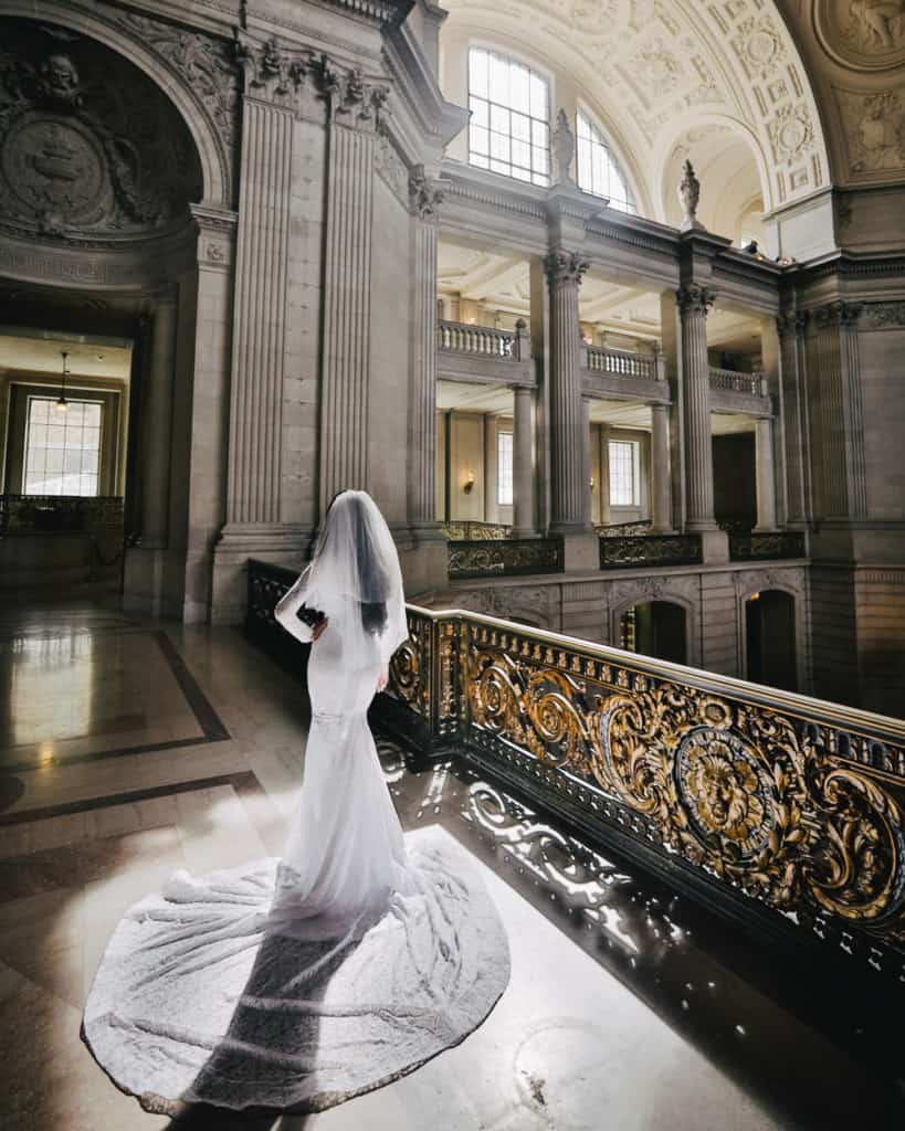 a stylish bride posing on the mayor's balcony in the sunlight