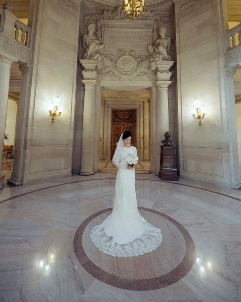 a bride with a long train dress posing in the rotunda