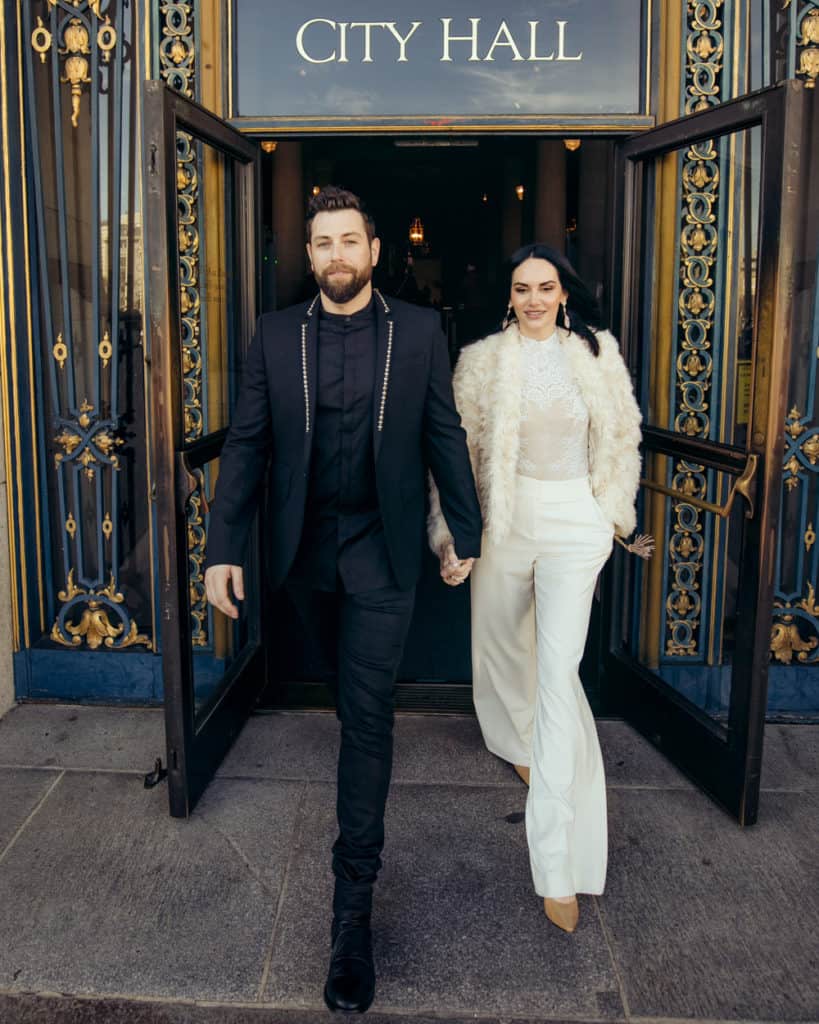 a stylish couple leaving sf city hall from the main entry