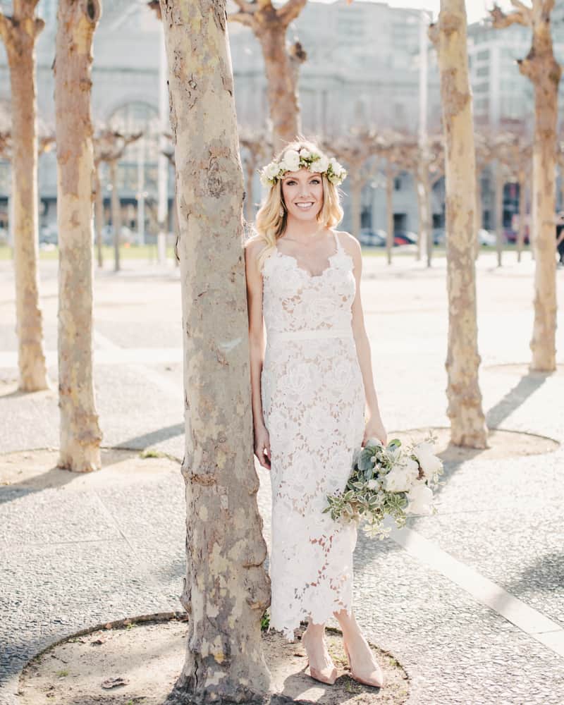 a bride in the short wedding gown posing outside of sf city hall in the park