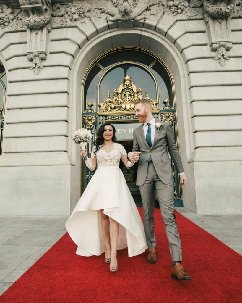 a couple walking on the red carpet at city hall