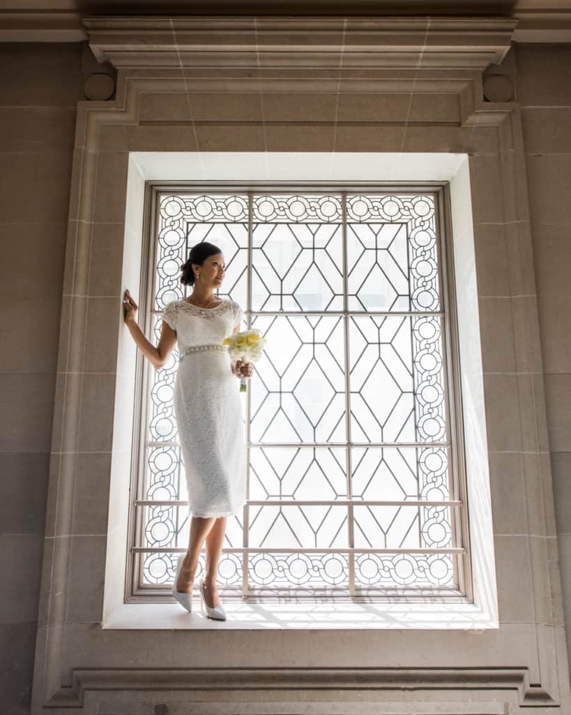 a bride standing on the 3rd froor window - white wedding gown